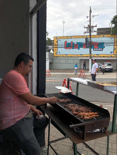 Aluno grelhando espetinhos na calçada